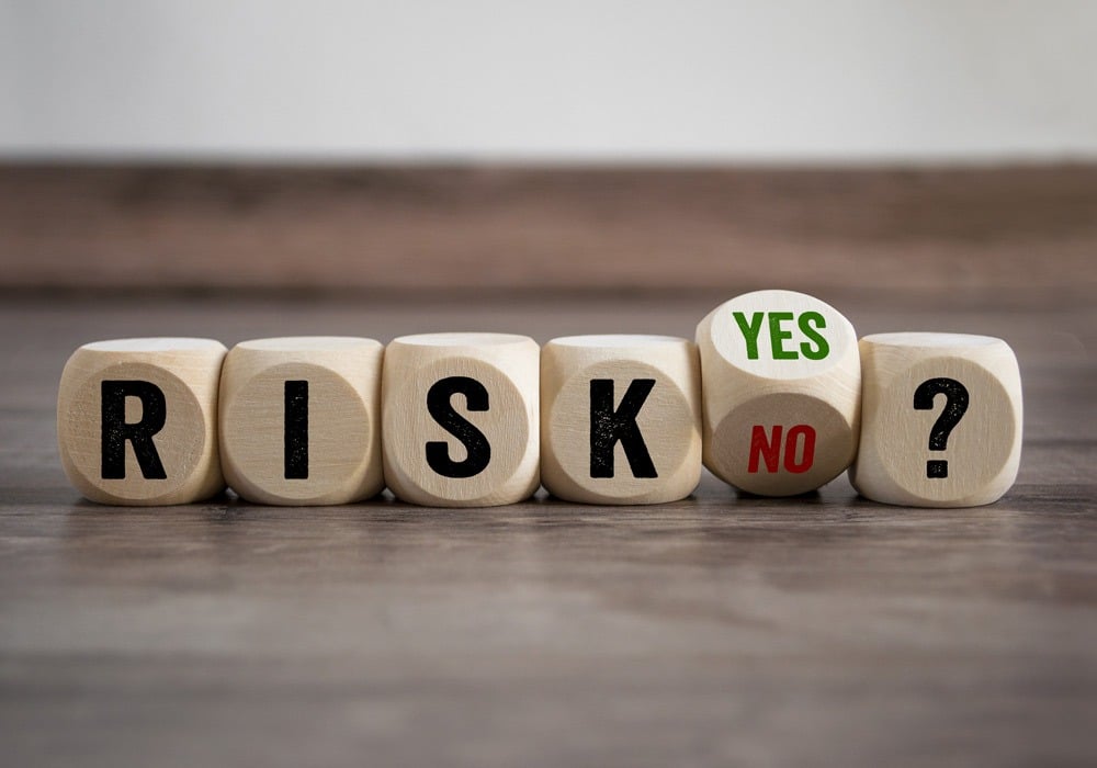 Adobe Stock image of dice spelling out Risk? Yes No on wooden table