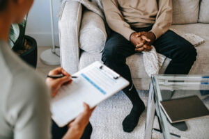 Therapist taking notes on male patient