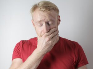 Blonde haired man looking distressed