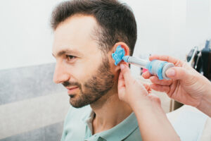 Man having ear impression taken for custom ear mould