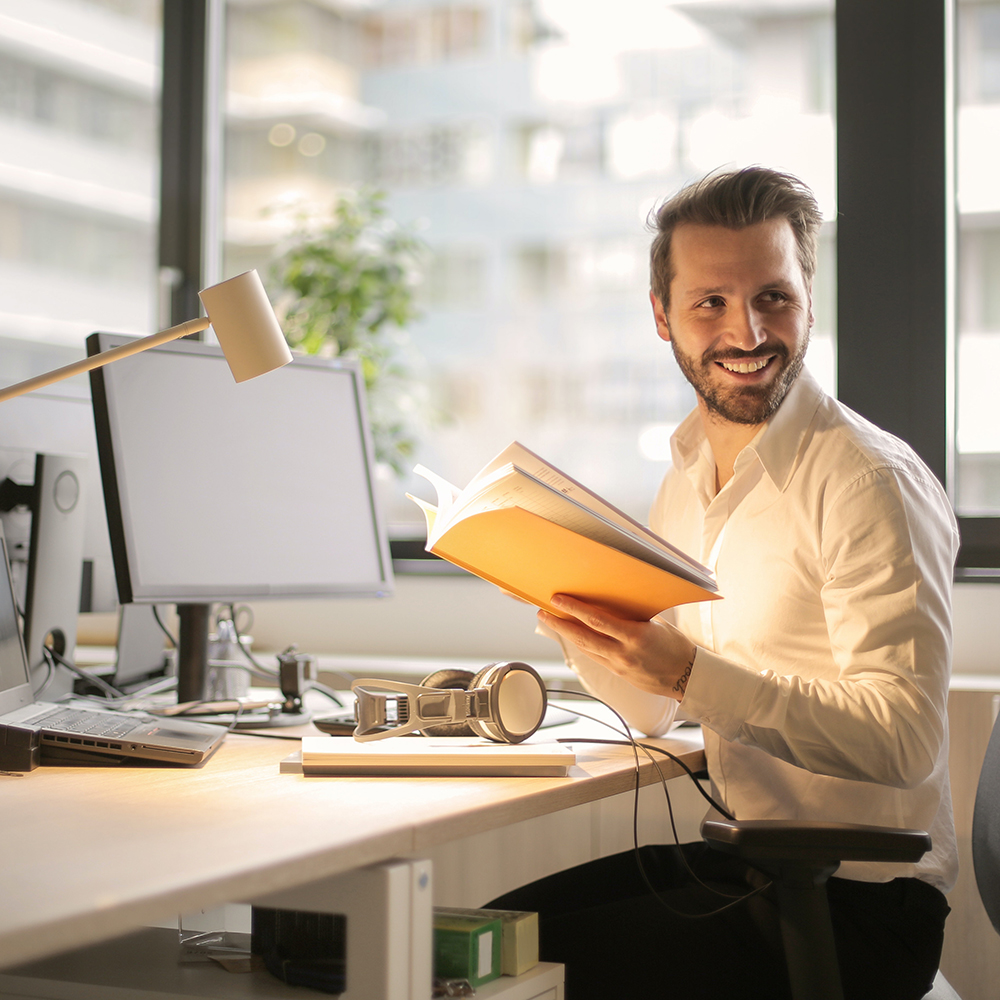 Male employee smiling, appearing happy at the workplace