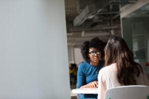 Two women having a conversation sitting at table