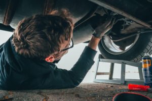 Brown haired man repairing vehicle