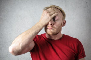 Depressed looking middle aged man holding his head in frustration