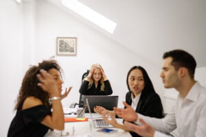 Four visibly frustrated employees having a work meeting