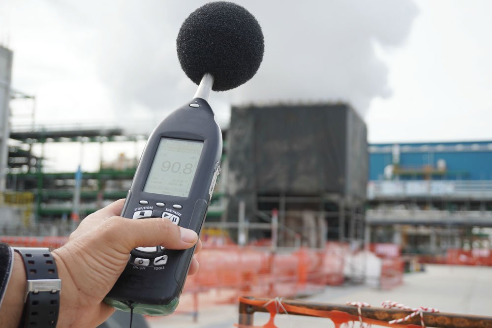 Hand of health and safety officer holding sound level meter