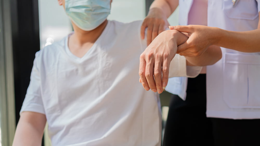 Doctor performing physiotherapy on male patient