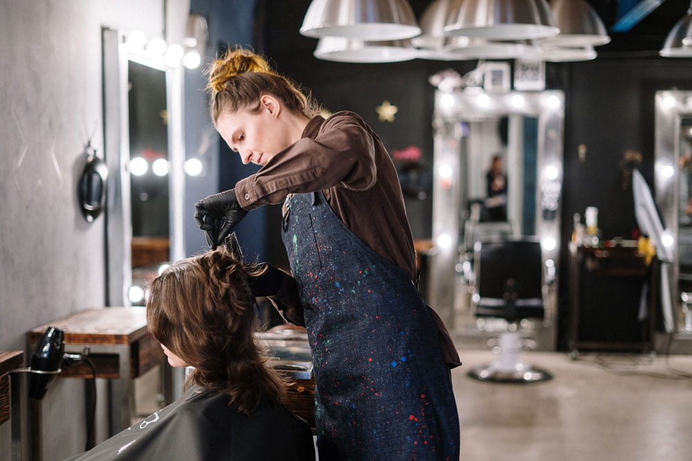 Hairdresser curling a woman's hair