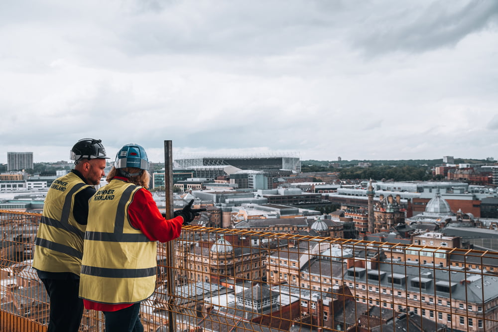 Construction workers having a conversation while looking out at city