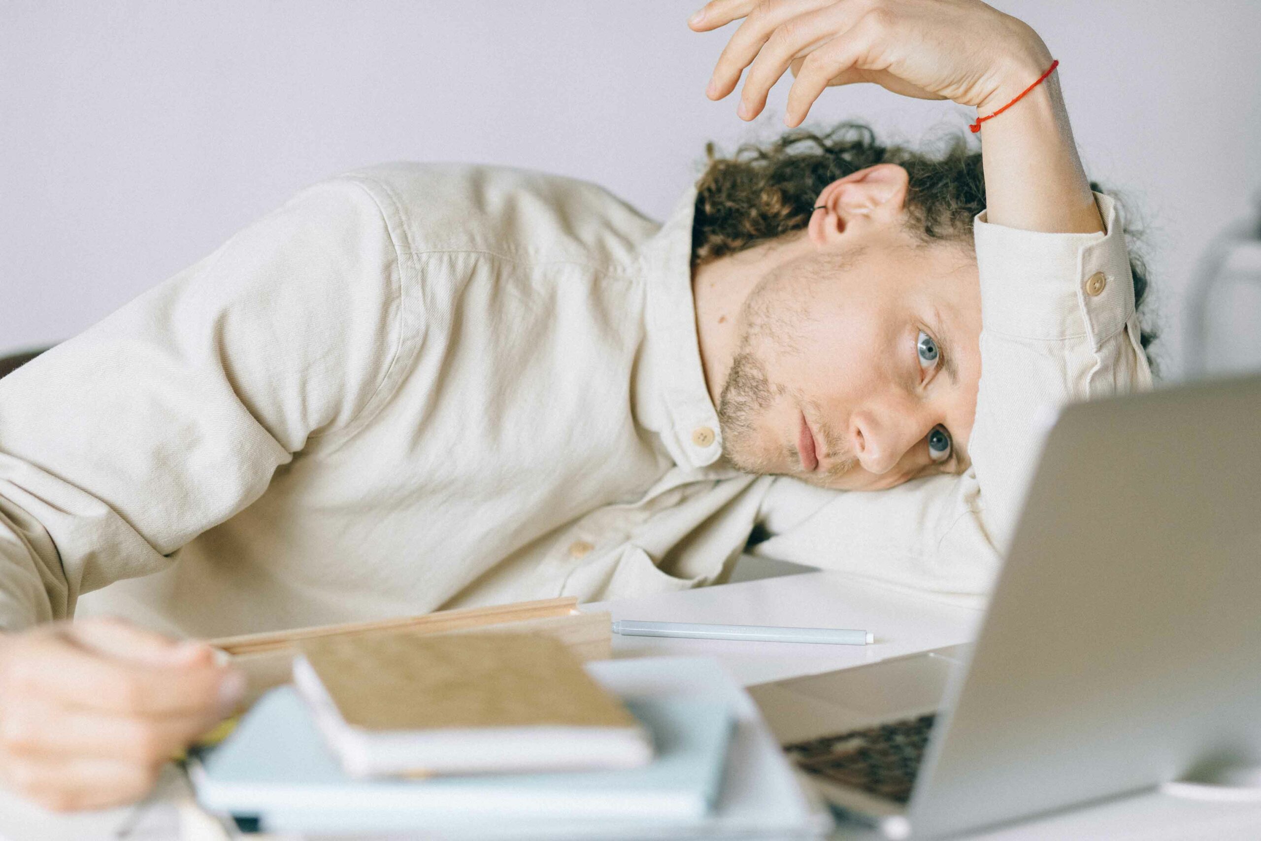 Tired-looking employee leaning his head on his arm