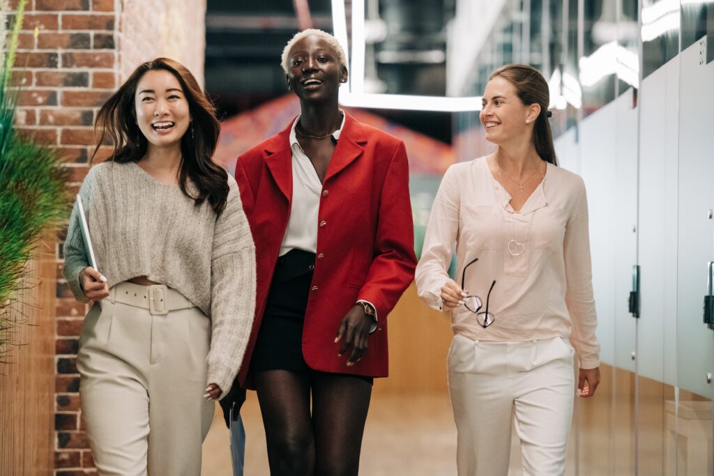 Three happy-looking employees walking down corridor