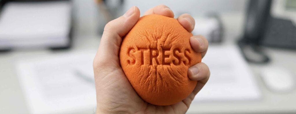 A orange stress ball with stress written on it.