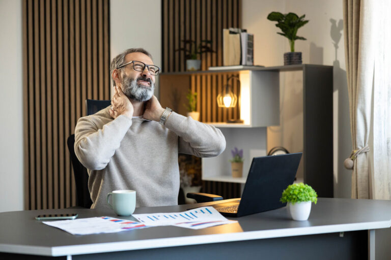 a man who has neck pain while remote working.
