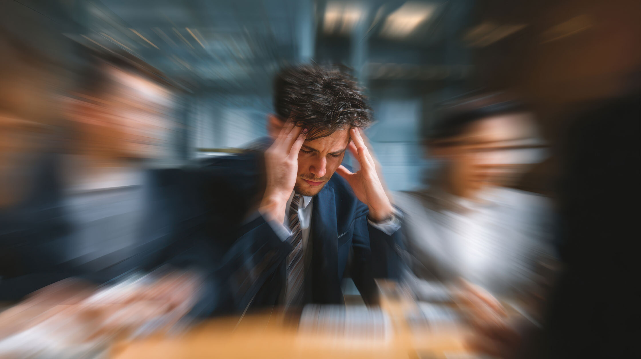 a man with people around him is stressed affected by fatigue in the workplace.