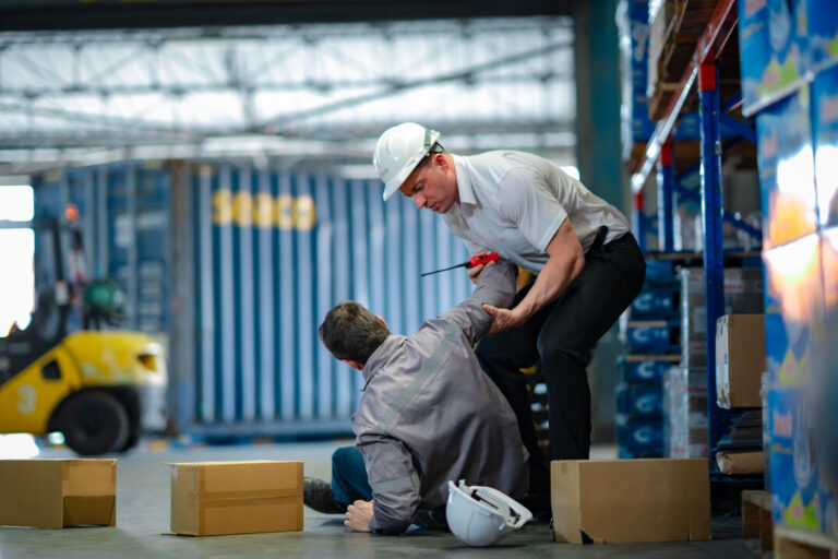 a man helping another man to get off the floor